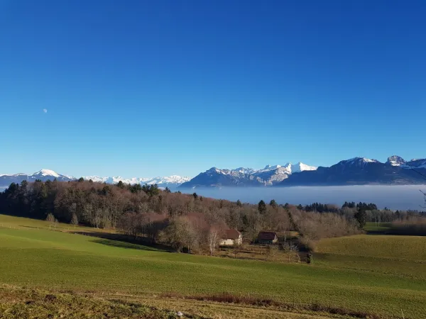 Vue sur les champs et montagnes enneigées depuis La Chapelle-Rambaud