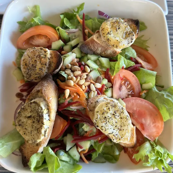 assiette salade verte tomate croûtons fromage de chèvre pignons de pin