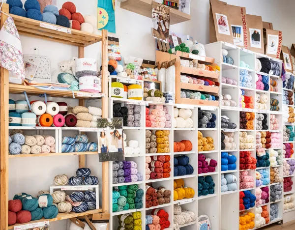 boutique avec l'étagère de pelottes de laines colorées