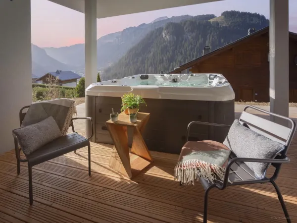 Terrasse couverte avec bain à remous, salon de jardin, vue sur les montagnes