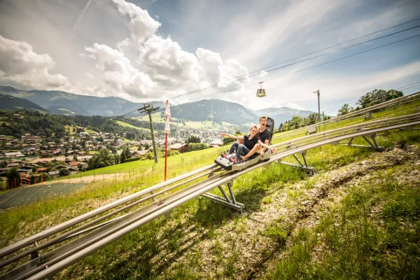 Enfant sur luge avec en fond télécabine Jaillet et village Megève