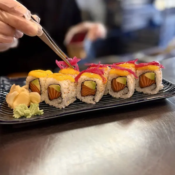 Maki inversé au saumon, avocat, mangue et pickles.