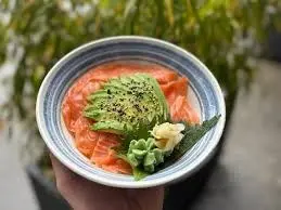 Bol de riz vinaigré garni de saumon et d’avocat.