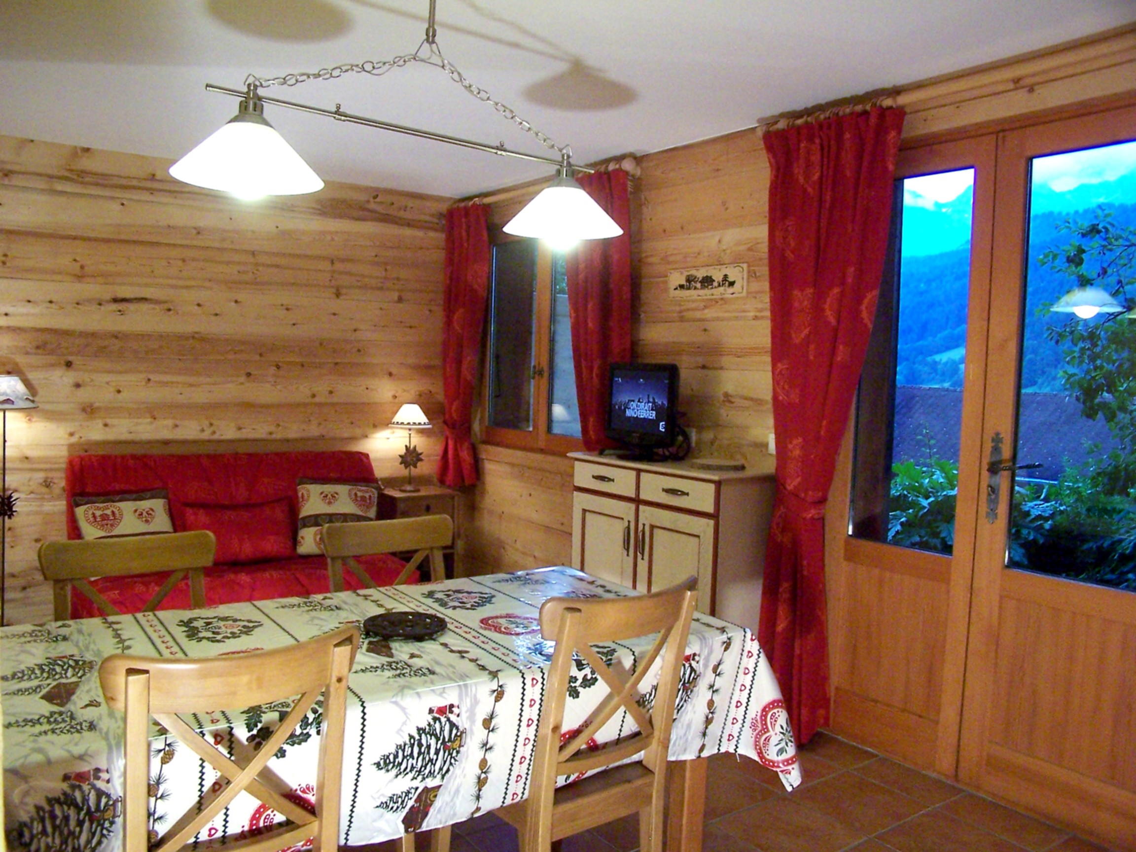 Séjour avec canapé et télévision, salle à manger/Living room with a sofa and a television, dining room-Buissière n°2-Le Grand-Bornand