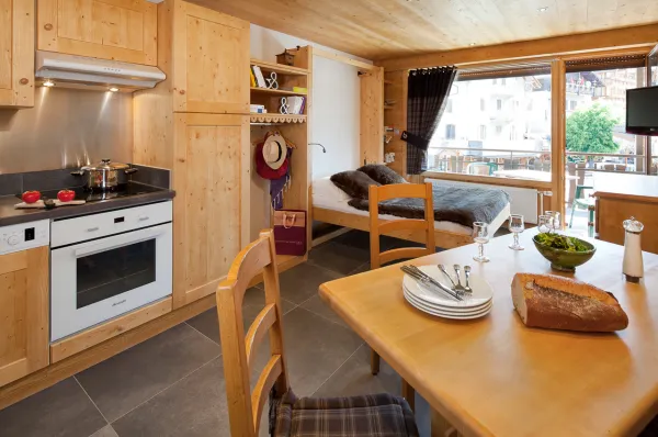 Séjour avec lit double et télévision, salle à manger et cuisine/Living room with a double bed and a television, dining room and kitchen-Forclaz C n°32-Le Grand-Bornand