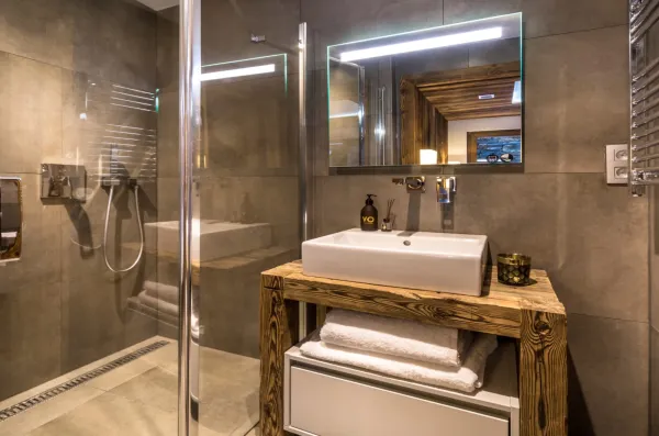 Salle d'eau avec grande douche à l'italienne et meuble vasque type établie, mur et sol en pierre grise