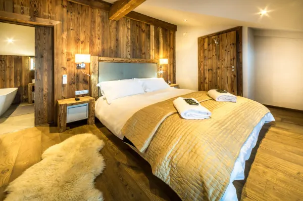 Chambre avec lit double tres chaleureuse et ambiance chalet rustique, avec salle de bains privée
