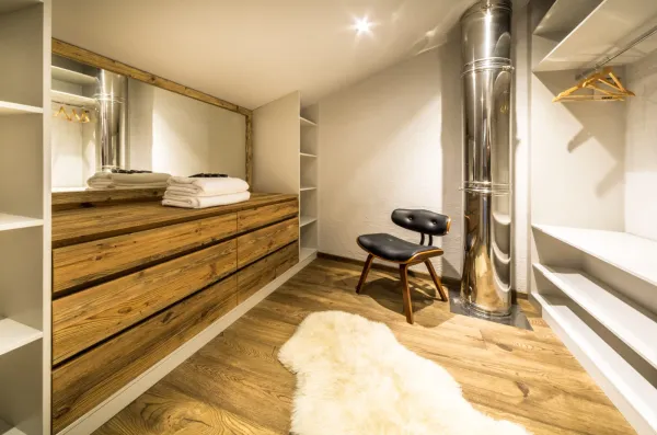 Dressing sous pente avec de nombreux rangements et une grande penderie, un long miroir dans une déco tres moderne et raffiné