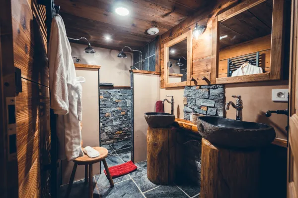 Salle de bains avec double vasque et double douche, décoration pierres et bois