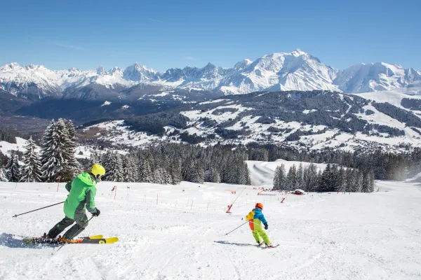 Famille de skieurs face au Mont-Blanc sur la piste bleue de la Bel Ava